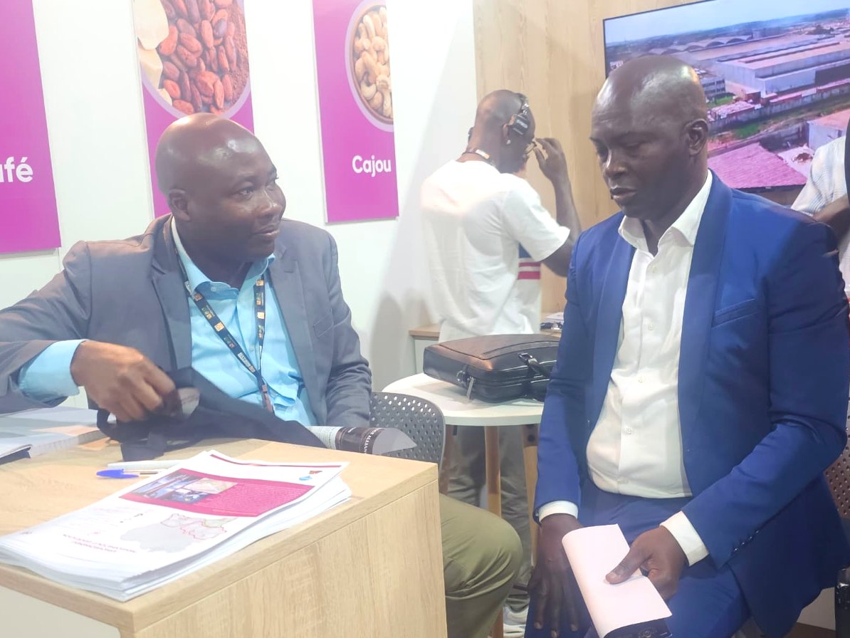 Cocoa Bridge Alliance delegation in discussion at an exhibitor stand during JNCC 2026 in Abidjan